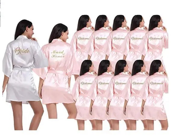 Light pink satin bridesmaid robes featuring 'Bride' and 'Maid of Honor' embroidery for elegant weddings.