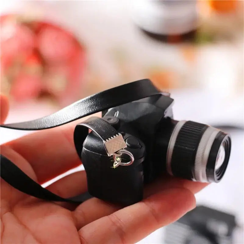 Mini camera for dollhouse photography in black, perfect for baby photo gifts and creative play.