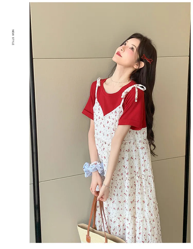 Model wearing a floral two-piece maternity dress with a red top and white skirt, showcasing a stylish summer look.