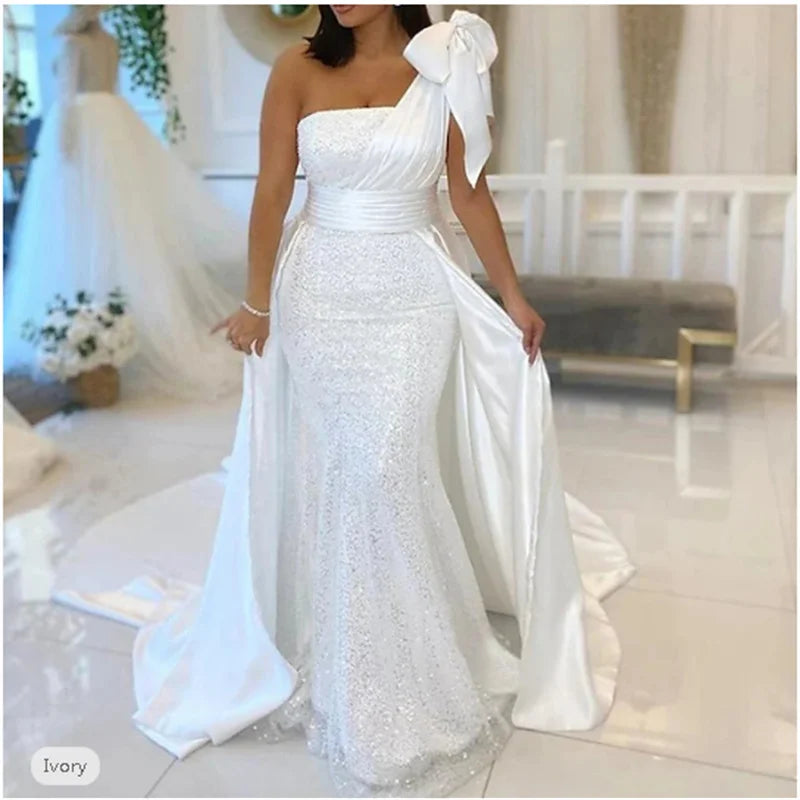 Ivory mermaid wedding dress featuring one shoulder design, sequined fabric, and a chapel train, perfect for elegant brides.