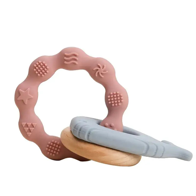 Soft silicone baby teether rings in pink and blue, safe for infants to relieve gum pain.