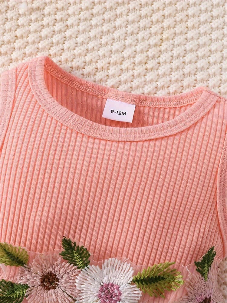 Close-up of a pink ribbed baby dress with floral embroidery, size tag 9-12M, perfect for summer wear.