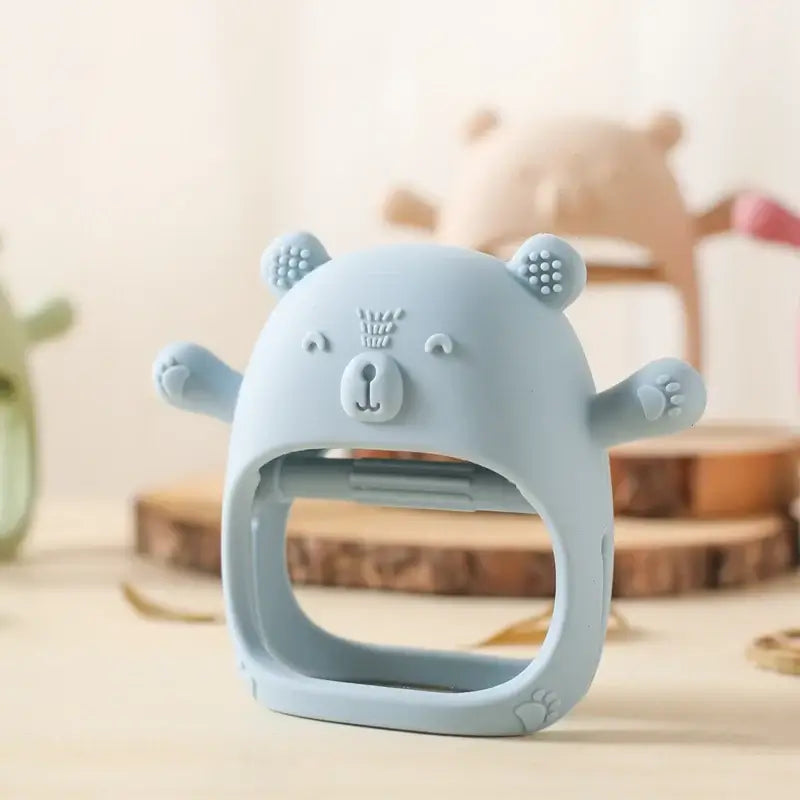 Light blue silicone baby teether glove shaped like a bear, designed to relieve teething pain for infants.