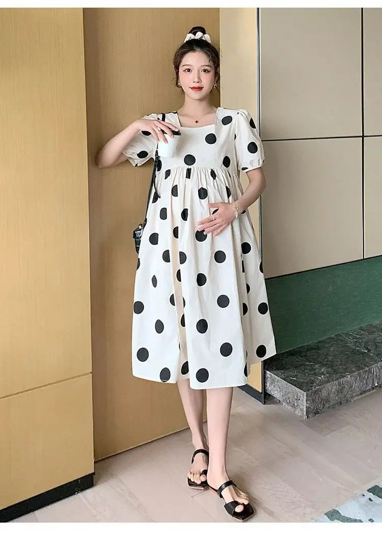 Polka dot loose maternity dress in white and black, perfect for summer, featuring a mid-calf length and short sleeves.