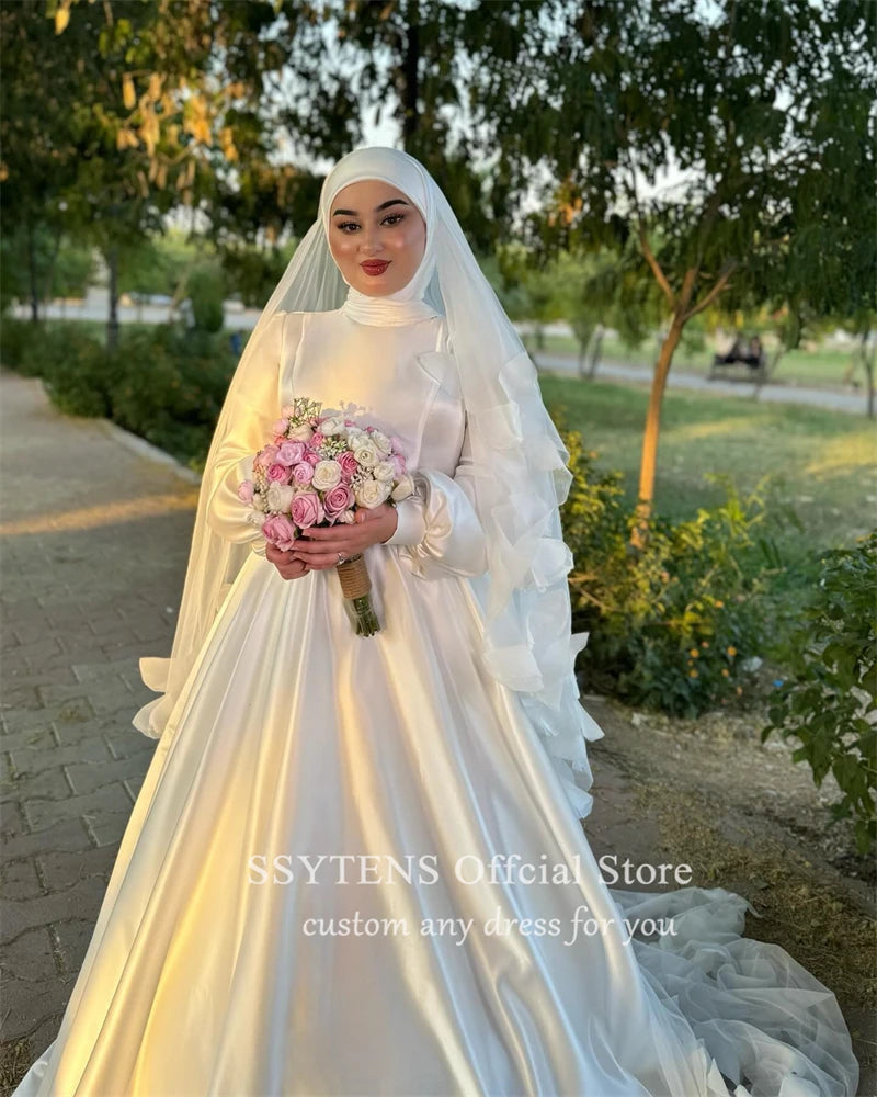 Elegant Muslim A-Line satin wedding dress with high collar, adorned with flowing sleeves, worn by a bride holding a bouquet.