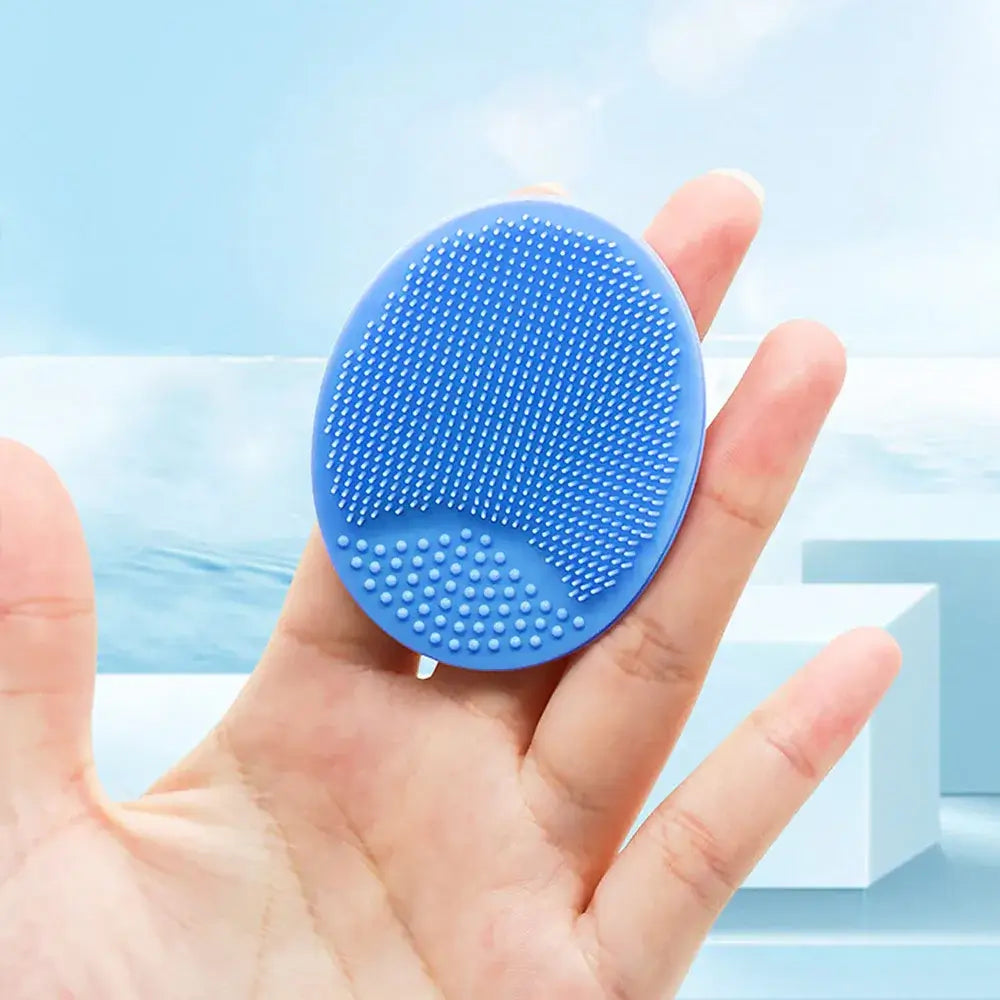 Blue silicone baby bath brush shown in a hand, ideal for newborn and infant care.