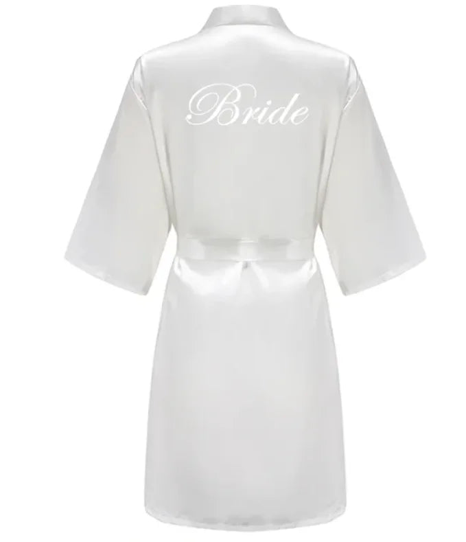 White satin bride robe with elegant script text on the back, perfect for bridal parties.