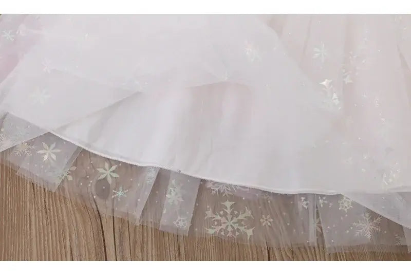 Close-up of white tulle fabric with floral patterns and a sparkling finish, ideal for summer dresses.