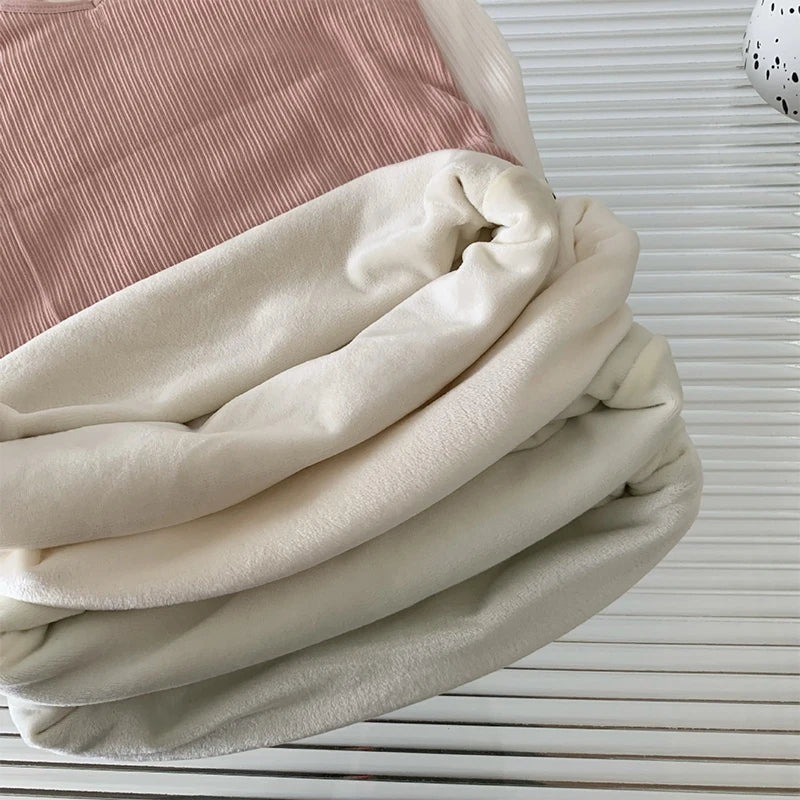 Folded casual velvet crop tank in cream and blush colors, showcasing sleek and comfortable fabric texture.