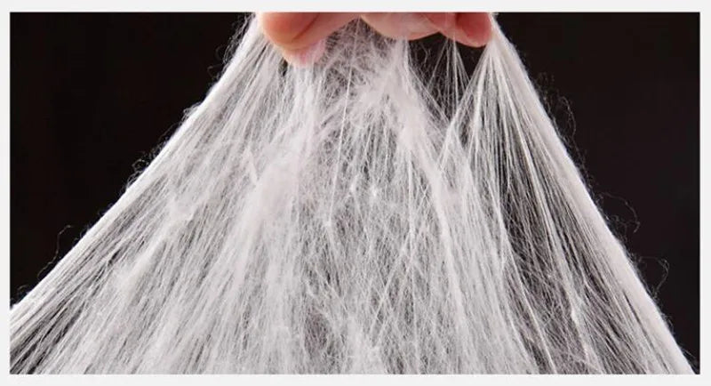 Close-up of a person holding soft, transparent strands of silk, showcasing its delicate texture and quality.