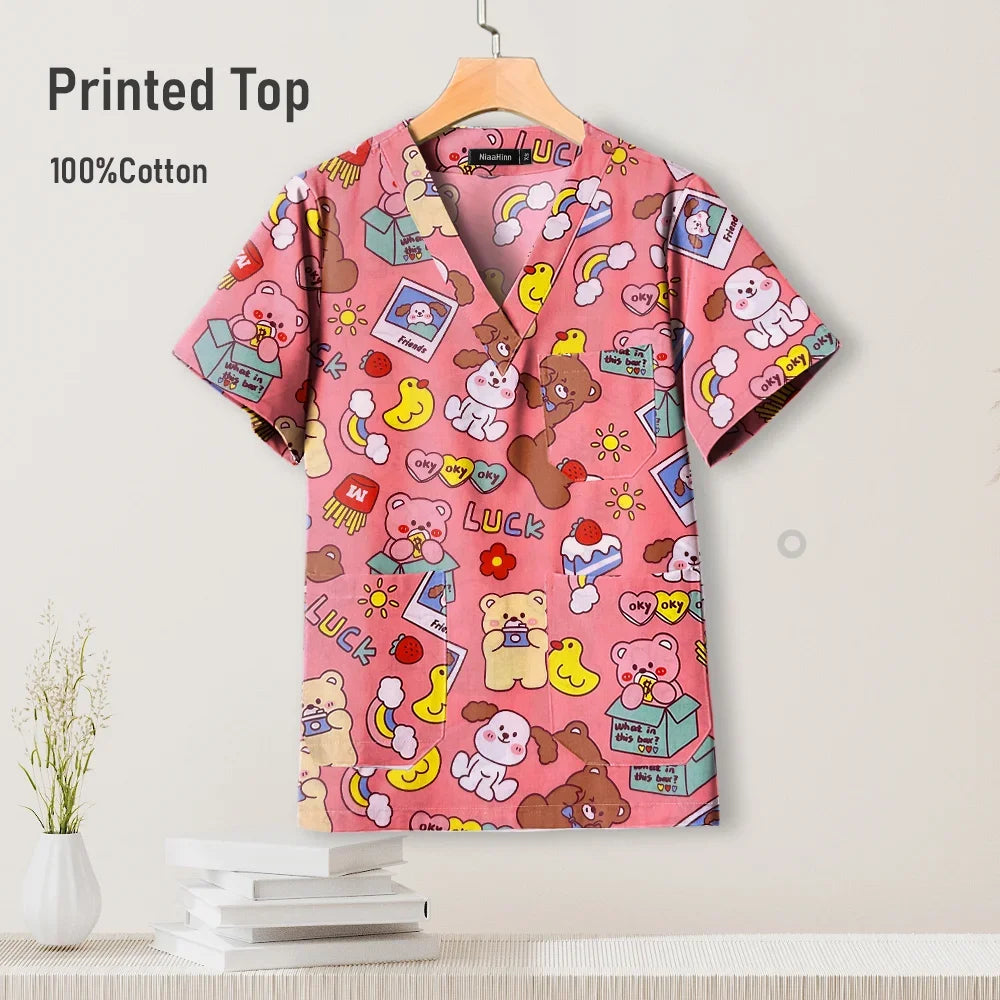 Cute printed pediatric nursing scrub top in pink, 100% cotton, featuring playful designs for healthcare professionals.