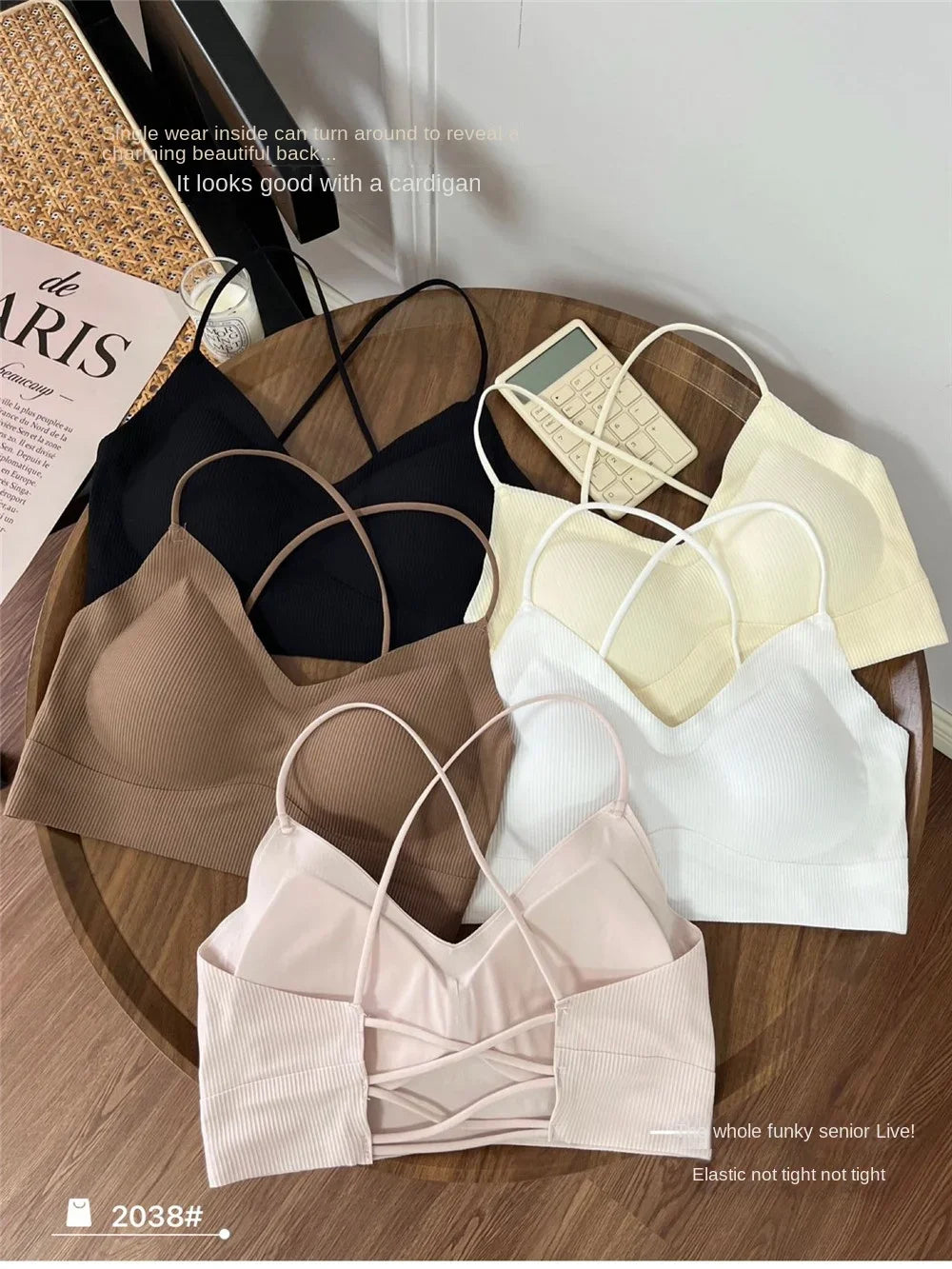 Display of six stylish padded backless tank tops in various colors on a wooden table.