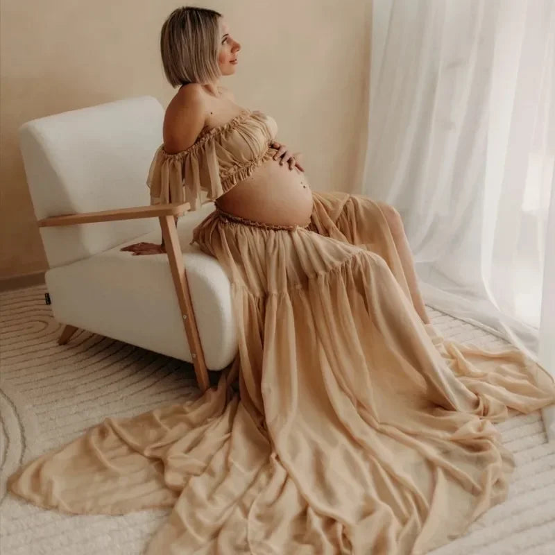 Stylish pregnant woman in a boho two-piece maternity set sitting in a serene setting, showcasing elegance and comfort.