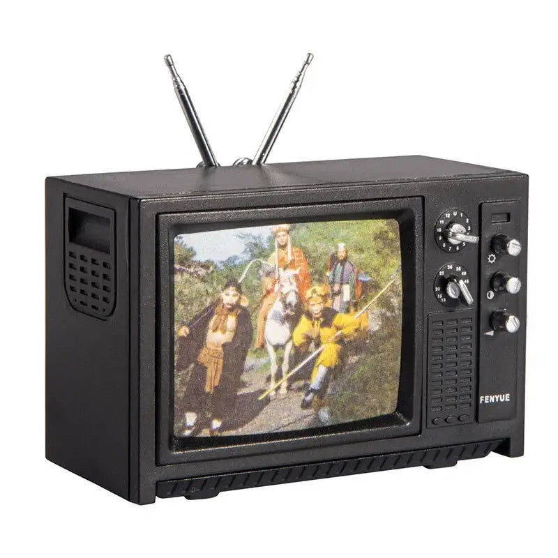 Miniature vintage television set with antenna displaying a scene of people in traditional clothing.