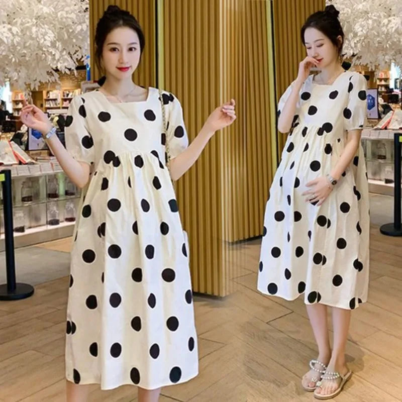 Polka dot loose maternity dress in white and black, perfect for summer, featuring a ball gown silhouette and short sleeves.