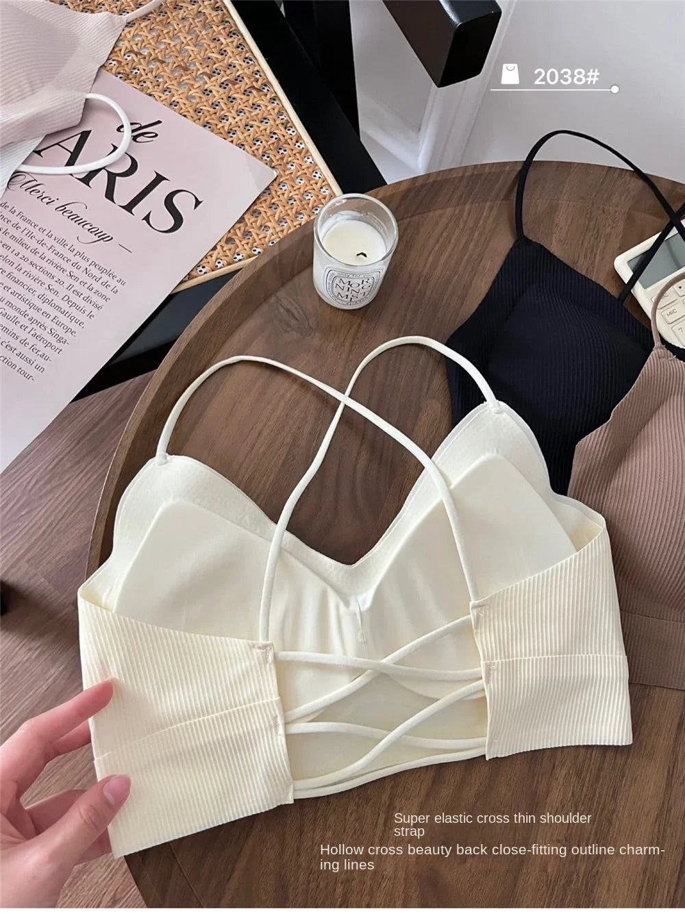 CrossForm™ padded backless tank top in cream on wooden table with black top and fashion magazine.