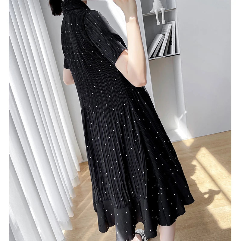 Styling of a black polka dot maternity dress with short sleeves, showcasing a flowy A-line silhouette for summer wear.