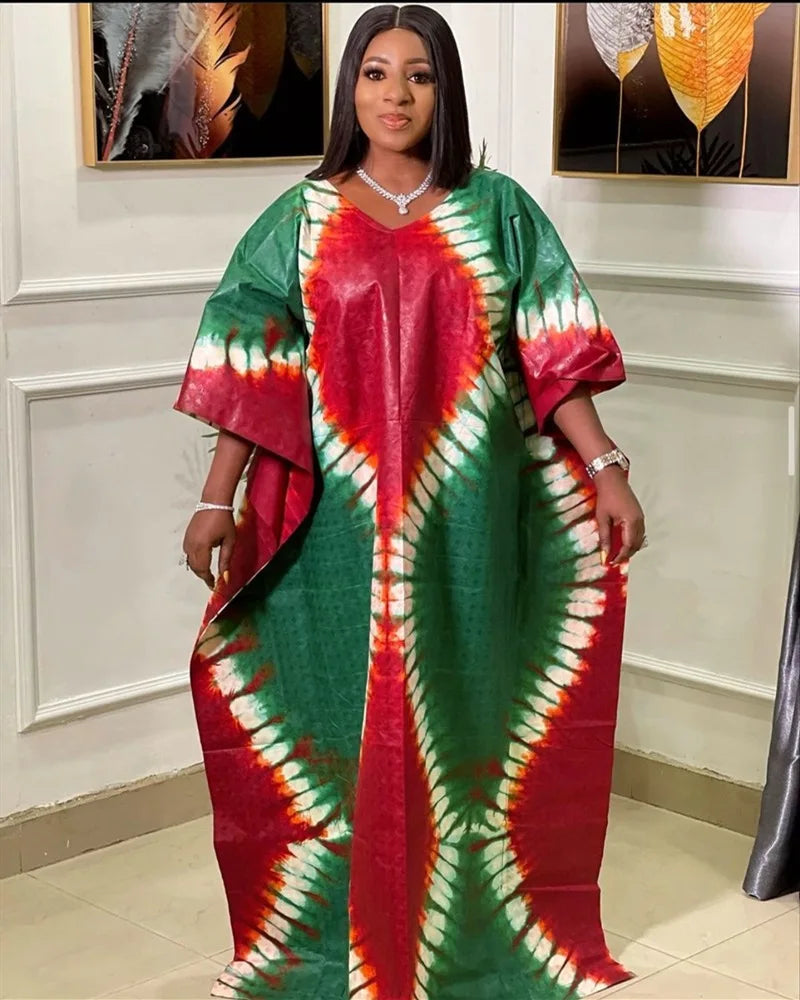 Woman wearing a vibrant African plus size printed long maxi dress in green and red patterns, showcasing traditional style.