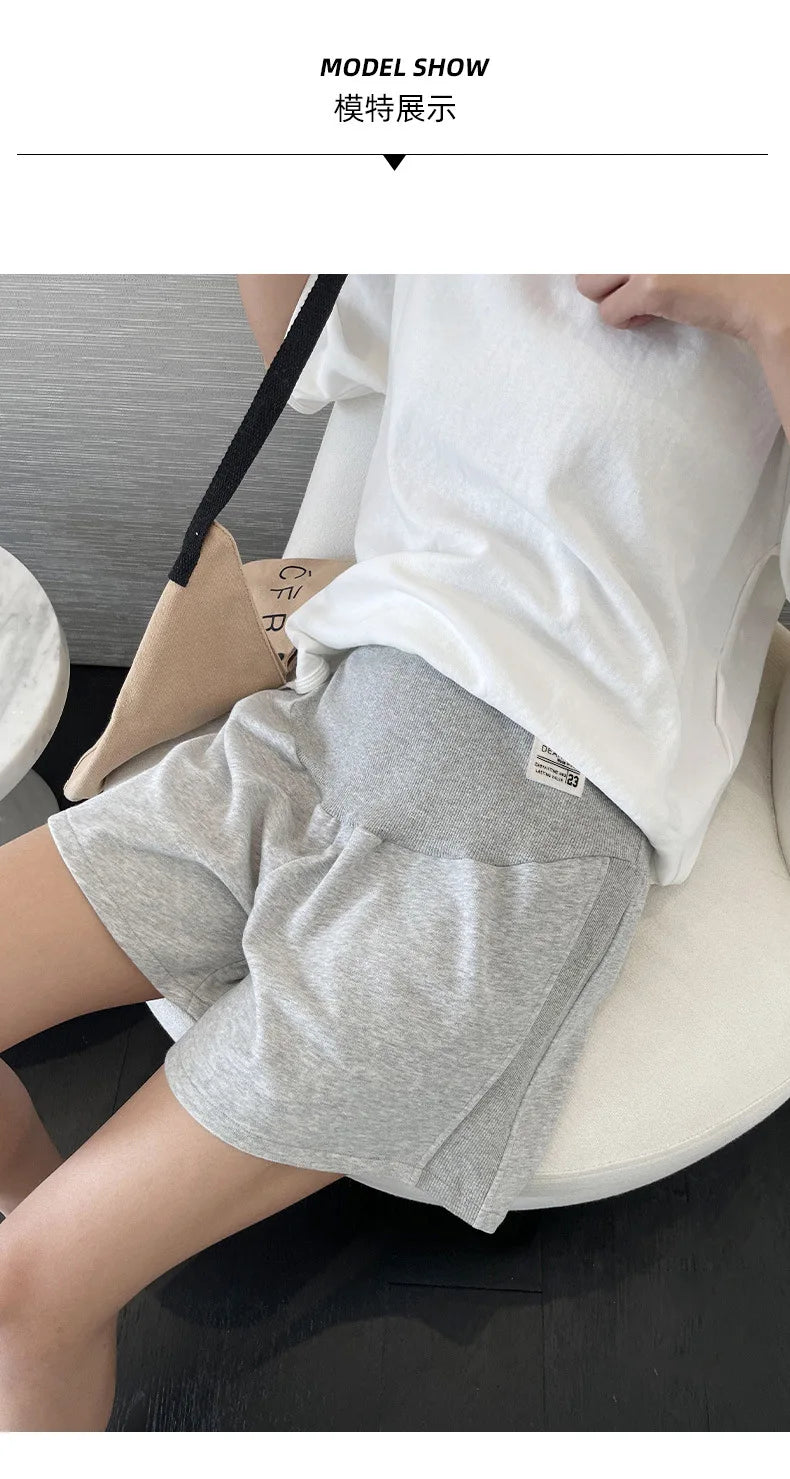 Model wearing gray plus size adjustable maternity shorts, showcasing a loose capri style, perfect for summer comfort.