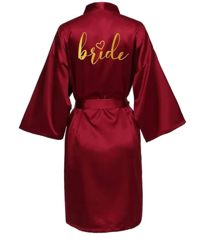 Elegant burgundy satin bride robe with gold lettering, perfect for bridal parties and special occasions.