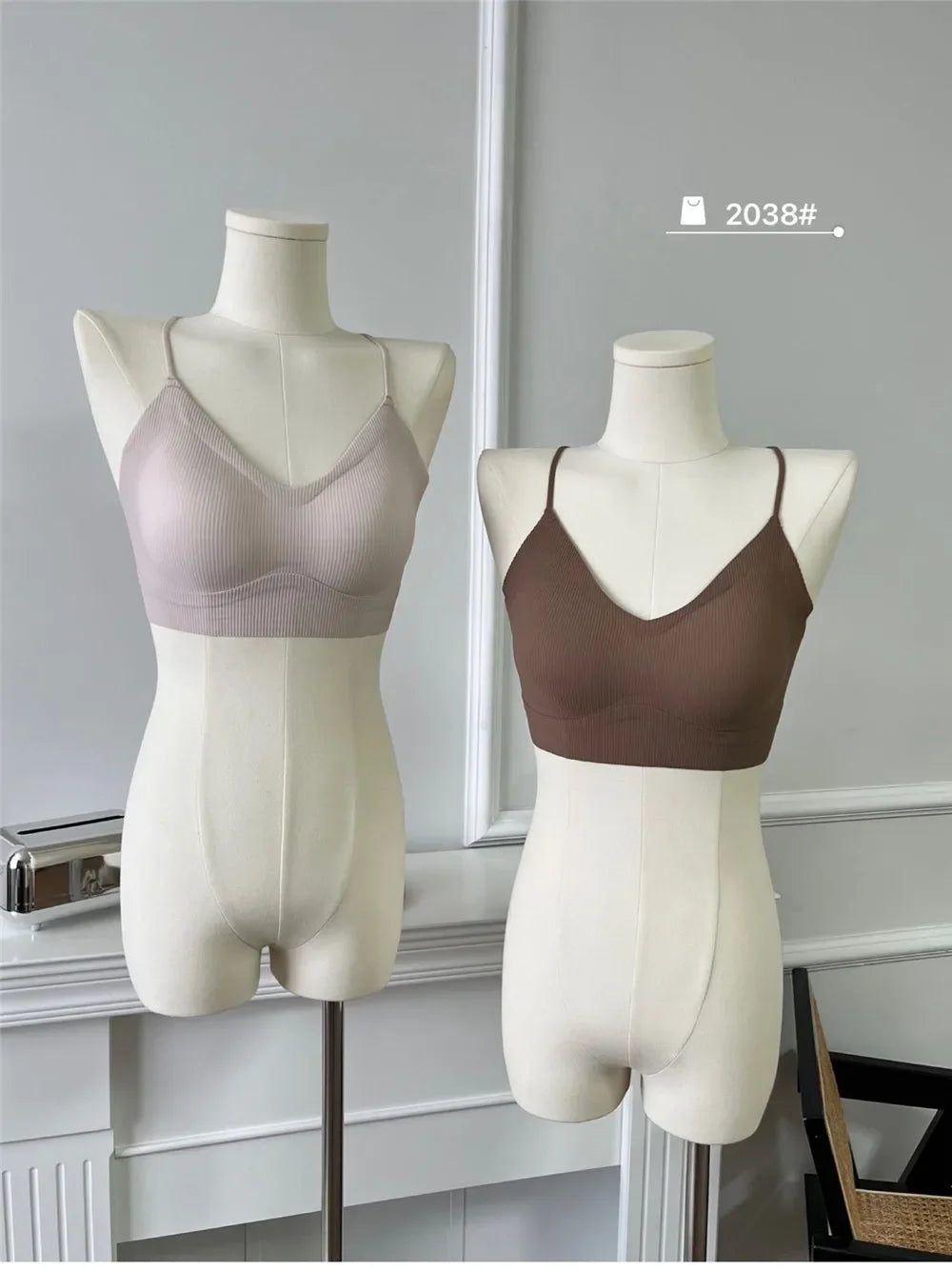 Two stylish women's padded backless tank tops displayed on mannequins, showcasing light pink and brown colors.