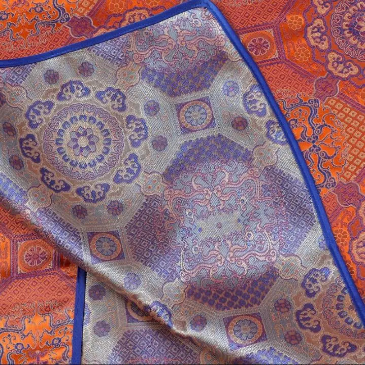 Close-up of vibrant Mongolian fabric showcasing intricate patterns and rich colors, ideal for traditional women's clothing.