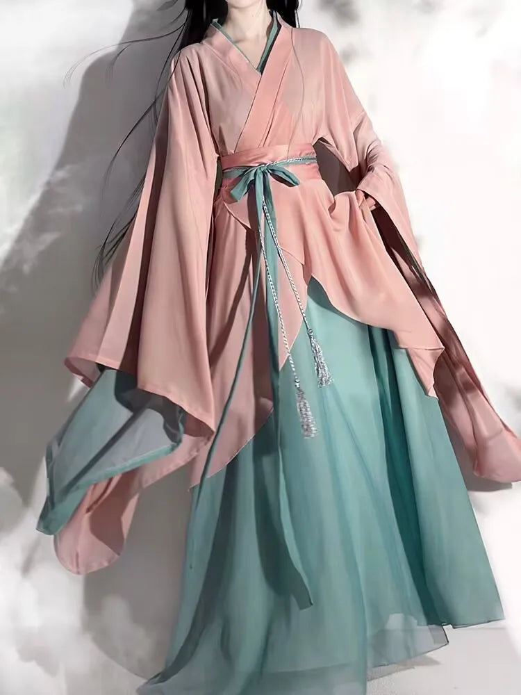 Elegant vintage cosplay costume featuring flowing pink and teal Hanfu dress with wide sleeves.