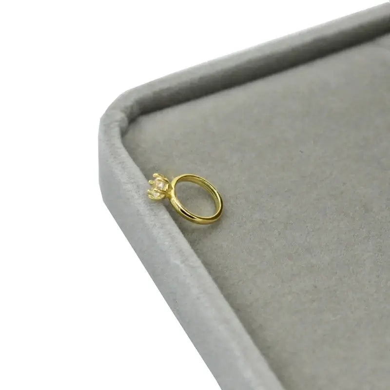 Exquisite newborn baby angel ring in gold, crafted for ages 0-6 months, displayed on a soft gray velvet box.