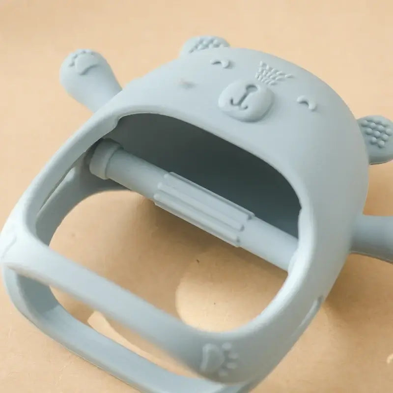 Blue silicone baby teether glove with bear design for soothing teething discomfort in infants.