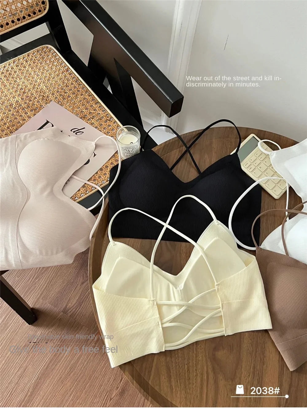 Variety of CrossForm™ padded backless tank tops in soft colors on a stylish chair, perfect for casual summer wear.