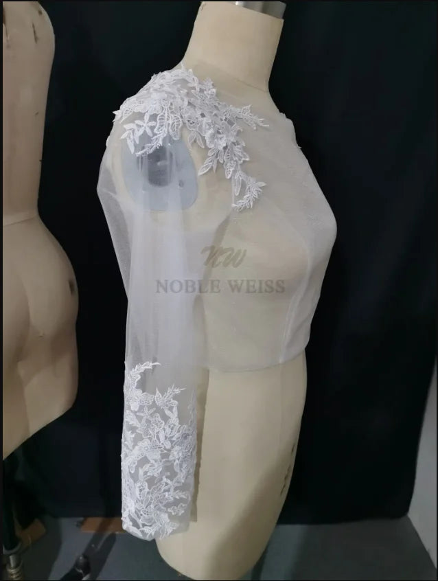 Lace Bridal Bolero by Noble Weiss, featuring long sleeves and delicate appliqued design for a stunning bridal look.