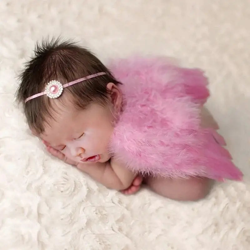 Newborn baby in pink angel wings and headband, perfect for photography props and costume outfits.