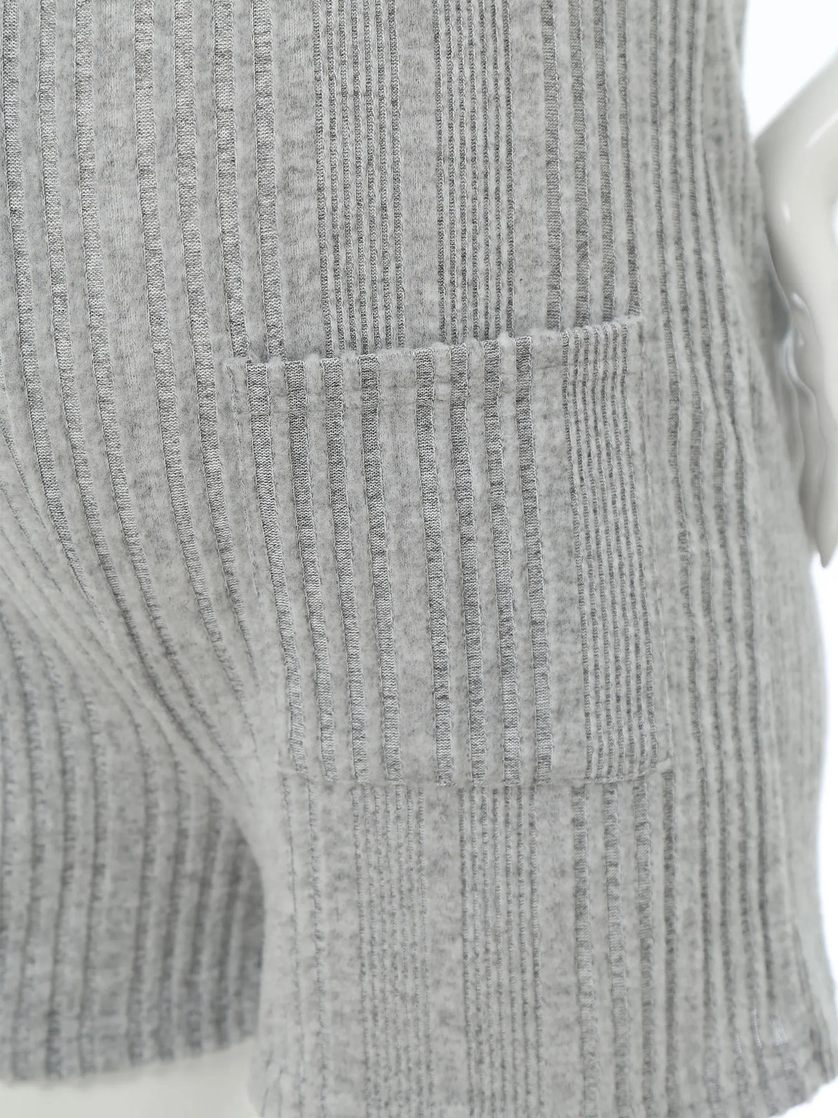 Close-up of a sleeveless ribbed maternity jumpsuit showing textured fabric and side pockets in gray.