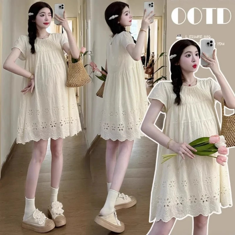 Woman modeling a knee-length A-line cotton maternity dress in natural color with lace embroidery, perfect for summer.