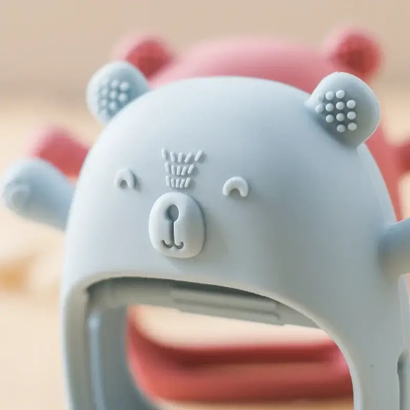 Cute baby teether glove in blue with bear design, made from soft, safe, non-toxic silicone for teething relief.