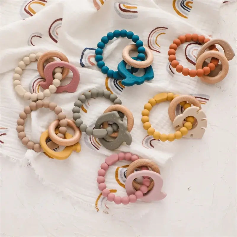Colorful silicone baby teether rings arranged on a cozy blanket, ideal for relieving teething pain and safe for infants.
