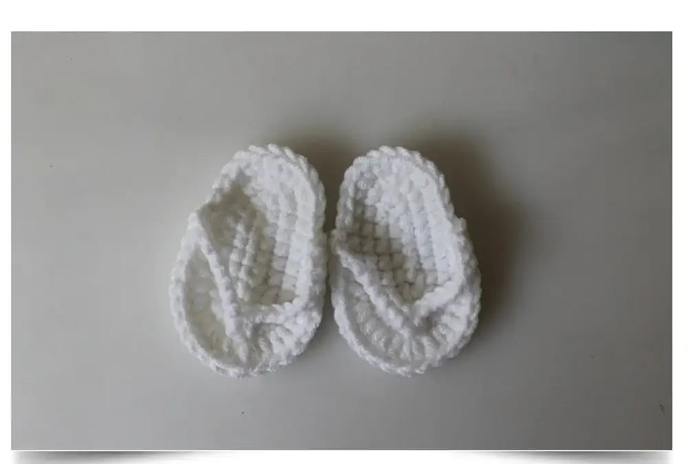Cute white knitted baby flip flops perfect for toddlers, soft and comfortable for little feet.