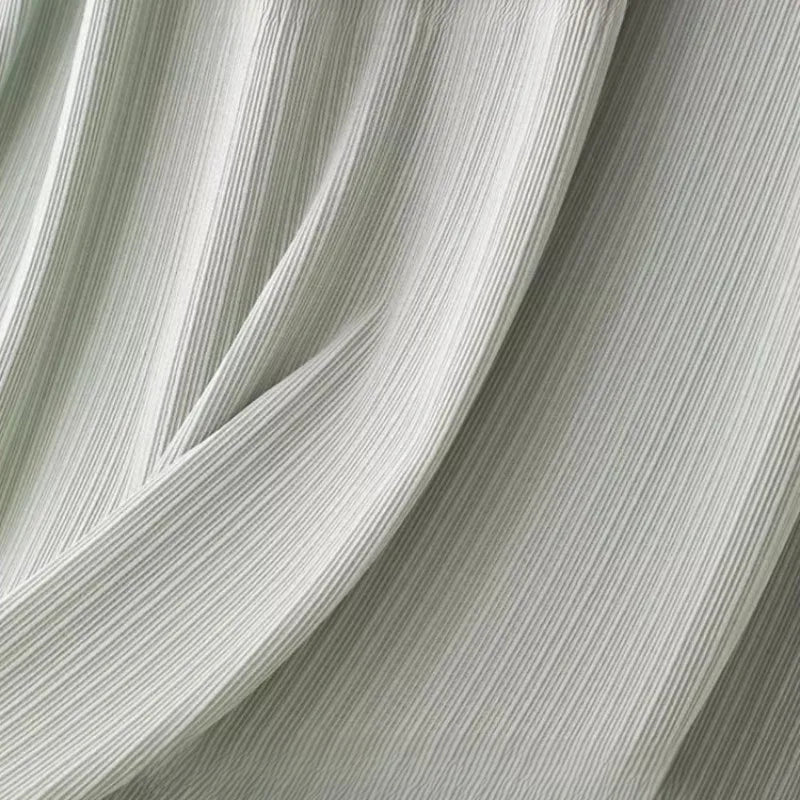 Close-up of lightweight polyester fabric, showcasing a soft, natural color texture for maternity dress design.