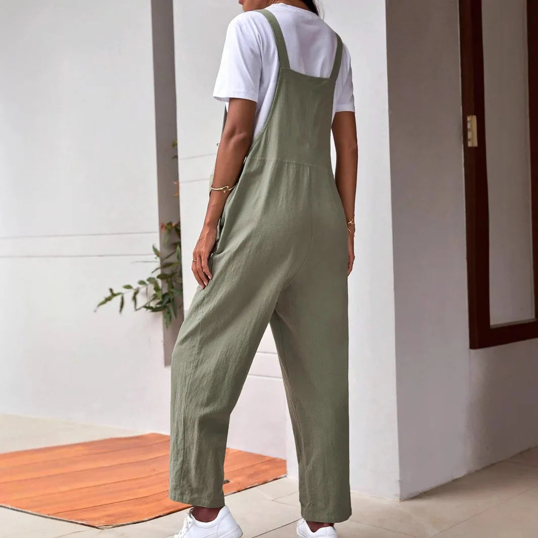 Woman wearing adjustable maternity overalls in olive green, showcasing a loose fit and casual style in a modern setting.