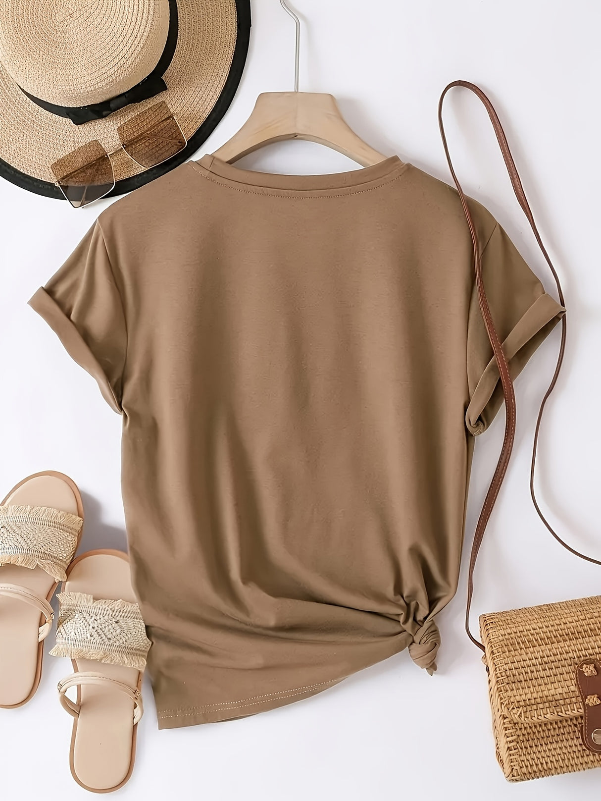 Elegant all-season round neck T-shirt in brown, styled with sandals, handbag, and sun hat for a chic casual look.