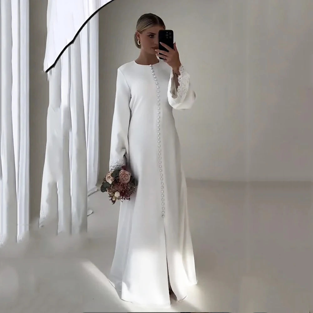 Elegant white satin mermaid wedding dress with long sleeves and floral bouquet.