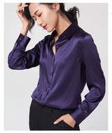 Model wearing a purple satin long sleeve silk blouse with a V-neck collar and single breasted closure.