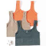 Three seamless ribbed camisoles in orange, beige, and green, perfect for women's fitness and casual wear.