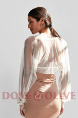 Model wearing a black tulle bridal cape, showcasing long sleeves and an elegant design, perfect for weddings.