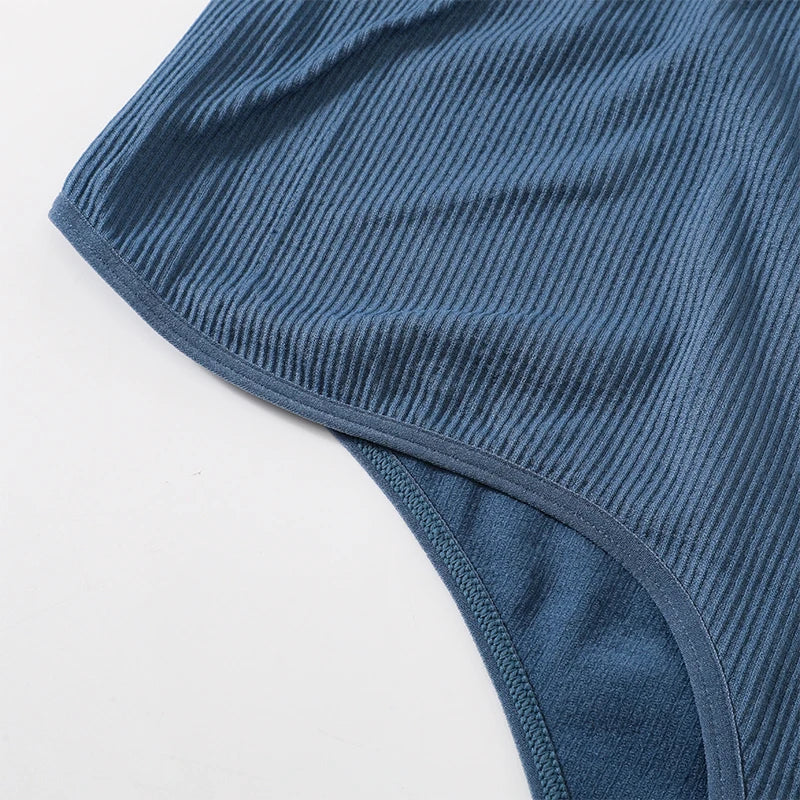 Close-up of the ribbed texture and hem of the MonoSculpt™ one-shoulder seamless crop top in blue.