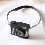 Black mini camera for dollhouse photography, ideal baby photo props, made of plastic and electronics.