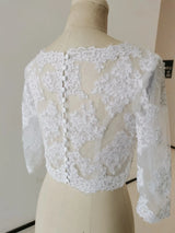 Back view of a crystal beaded wedding jacket with 3/4 sleeves, featuring intricate lace details and button closure.