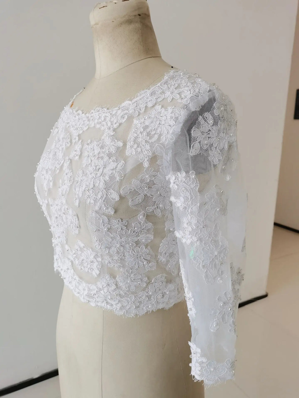 Elegant Crystal Lace Wedding Bolero with 3/4 sleeves, showcasing intricate embroidered details and soft white fabric.