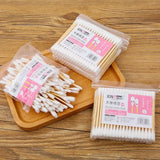 100pcs Baby Cotton Swabs in packaging on wooden surface, perfect for babies and toddlers, made from wood and cotton.