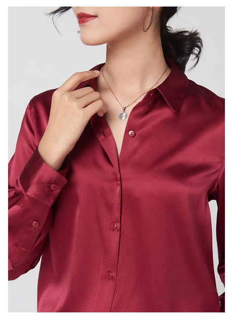 Close-up of a woman wearing a burgundy SatinGrace™ long sleeve silk shirt with a V-neck and necklace detail.